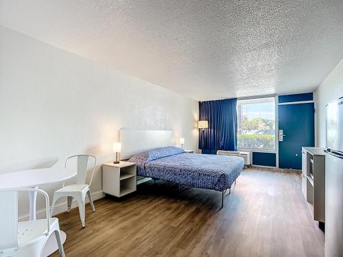 莱克兰Stayable Lakeland的一间卧室，配有一张床、一张书桌和一张桌子