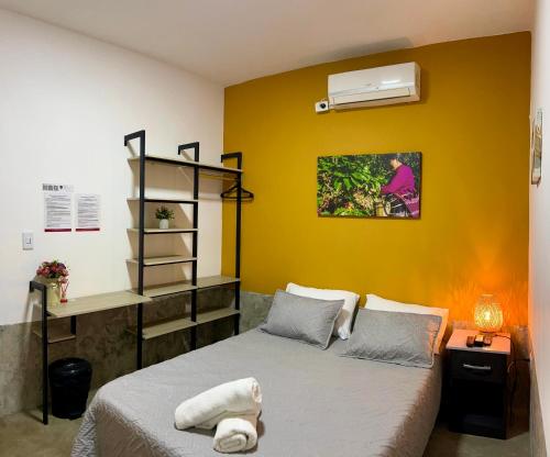 a bedroom with a bed and a yellow wall at Nómada22 -Hostal moderno en el centro de Neiva in Neiva