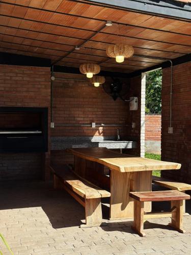 a patio with a wooden table and benches under a roof at Apartamento nuevo de 2 habitaciones cerca de Asunción 511 in Luque
