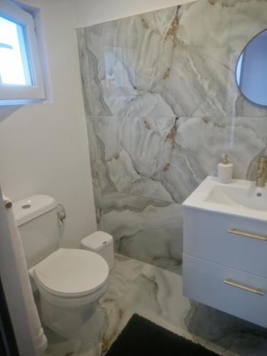 a bathroom with a white toilet and a sink at White Residence in Oradea