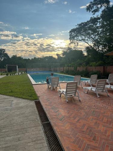 a group of chairs sitting next to a swimming pool at Apartamento nuevo de 2 habitaciones cerca de Asunción 511 in Luque