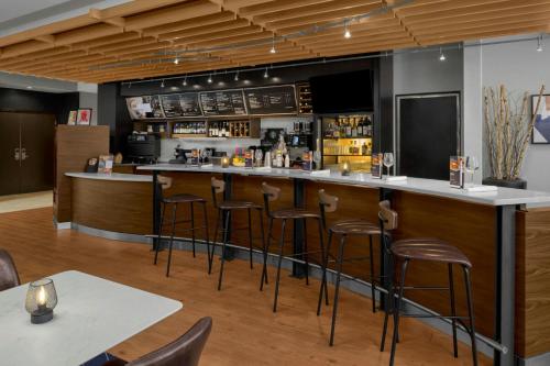 a bar in a restaurant with bar stools at Courtyard Pittsburgh Settlers Ridge/Robinson Township in Robinson Township