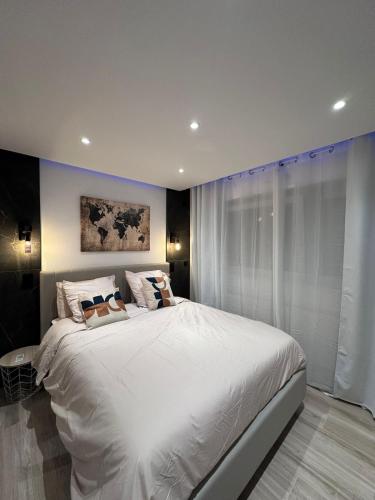 a bedroom with a large white bed in it at Très bel appartement PremiumSteinbach-parking in Mulhouse