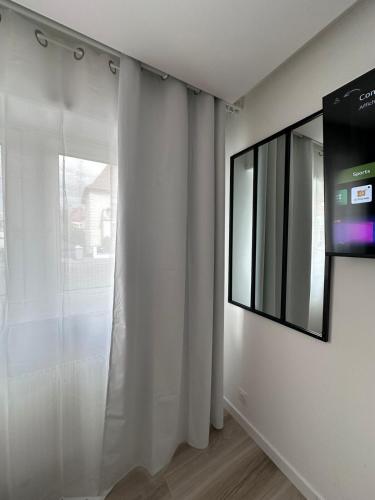 a living room with a tv and a window at Très bel appartement PremiumSteinbach-parking in Mulhouse