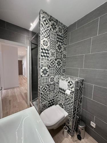 a bathroom with a toilet and a tub and tiles at Très bel appartement PremiumSteinbach-parking in Mulhouse