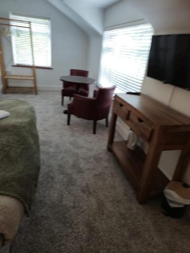 a hotel room with a bed and a desk with a television at The Park Lodge in Kinsale