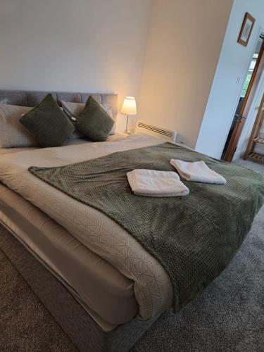a large bed with two towels on top of it at The Park Lodge in Kinsale