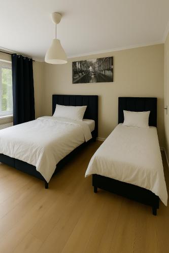 two beds sitting next to each other in a bedroom at Haven Hotel - Wuppertal in Wuppertal
