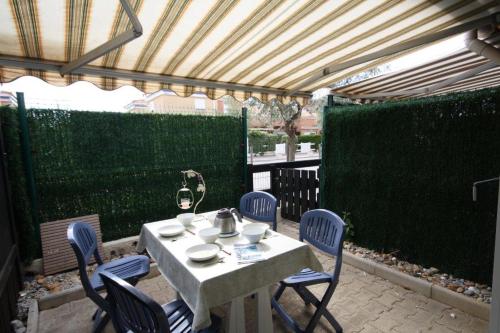 une table et des chaises assises sur une terrasse dans l'établissement Maison de plage, à Frontignan