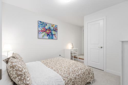 a white bedroom with a bed and a painting on the wall at CEDAR Double Room with attached private Bathroom and Balcony in Toronto, ON, Canada in Toronto