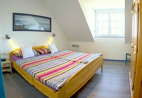 a bedroom with a large bed with a painting on the wall at Meeresbrise in Loperhet