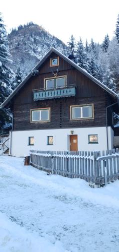 a wooden house with a fence in the snow at Ferienhaus Schellgaden in Muhr