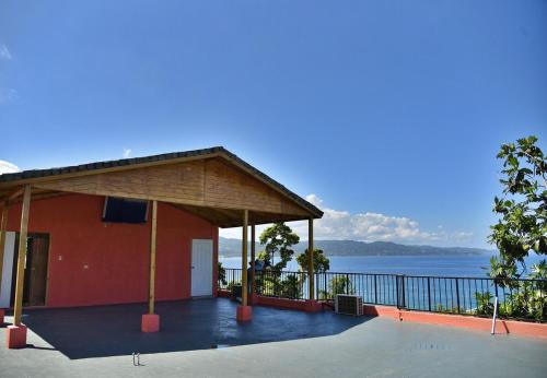 un edificio rojo con vistas al agua en LS Stonethrow - Sapphire Deluxe, en Montego Bay