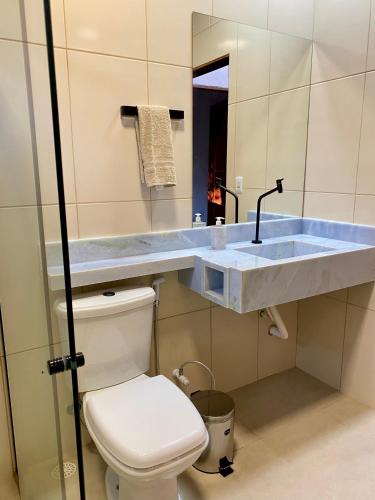 a bathroom with a toilet and a sink at Casa Lilás no Vale do Capão in Vale do Capao