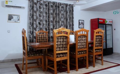 a dining room with a wooden table and chairs at CARL's VILLA APARTMENTS in Accra