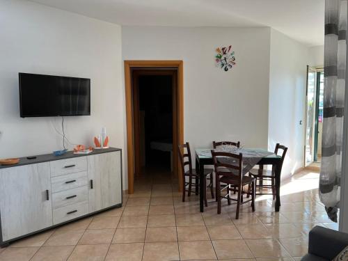 a dining room with a table and chairs and a television at Profumo di marzamemi in Marzamemi