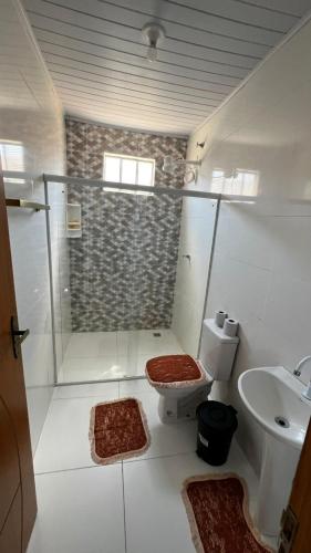 a bathroom with a shower and a toilet and a sink at Casa da Val in Conceição da Barra