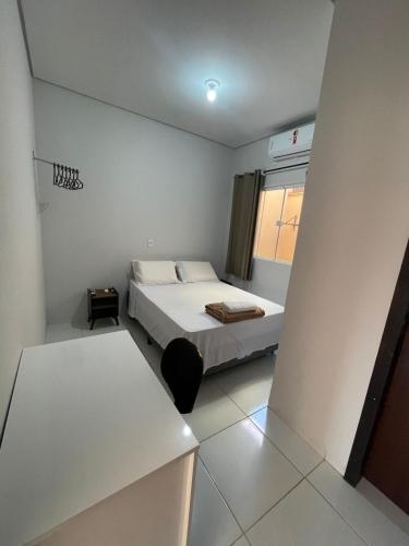 a small bedroom with a bed and a window at Apto entrada individual 1 in Sinop
