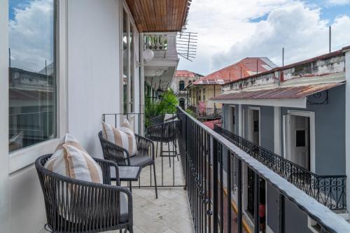 a balcony with chairs and tables on a building at Hotel Bardot Boutique in Panama City
