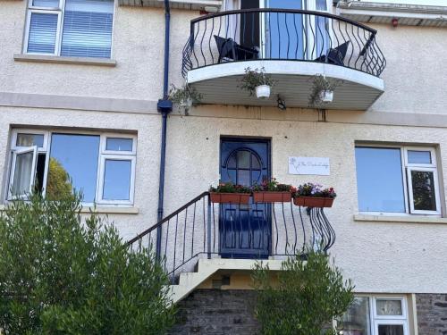 a building with a balcony with flowers on it at The Park Lodge in Kinsale