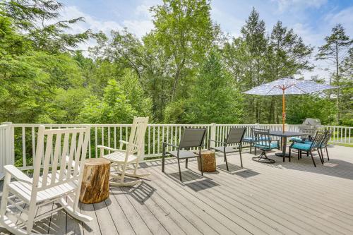 a deck with chairs and a table with an umbrella at Shohola Creek On-Site Updated Getaway with Deck! in Shohola