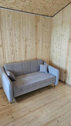 a couch sitting in a room with wooden walls at Sevan Barca Beach 2 in Sevan