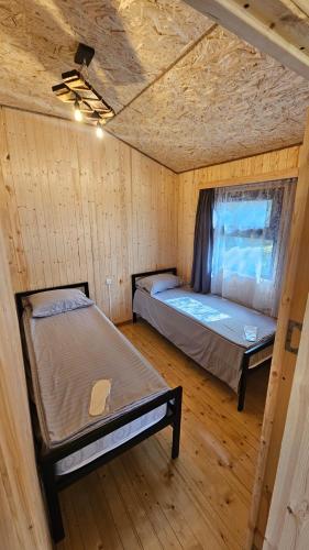 a bedroom with two beds in a wooden cabin at Sevan Barca Beach 2 in Sevan