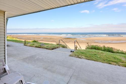 a porch with a view of the beach at 107 Ocean Picture Academy - Beachfront Condo - Pool Hot Tub & Full Kitchen in Lincoln City