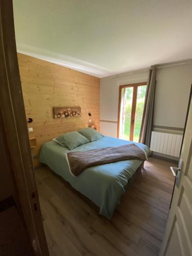 une chambre avec un grand lit avec un plancher en bois dans l'établissement Les Esplaneilles, à Formiguères