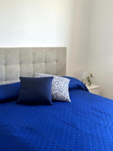 a blue bed with a blue comforter and a pillow at La Finestra Sul Mare in Tusa