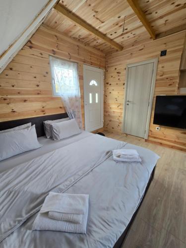 a bedroom with a large bed in a wooden cabin at Durmitor Viewpoint in Žabljak