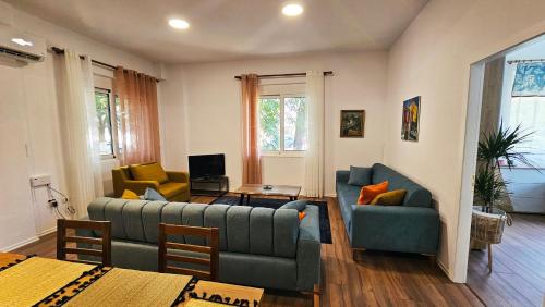a living room with two couches and a table at GjiroNest Apartment in Gjirokastër