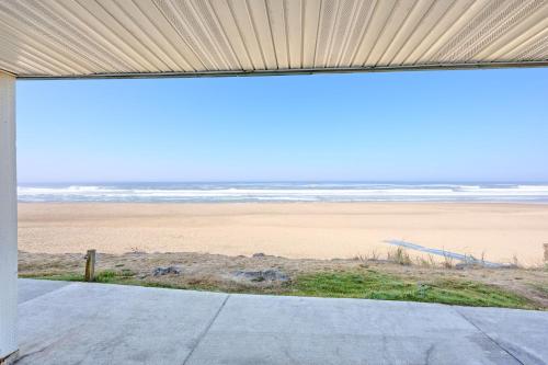 a view of the beach from the porch of a beach house at Beachfront Condo - Ground Floor - Ocean Views - Pool & Hot Tub in Lincoln City