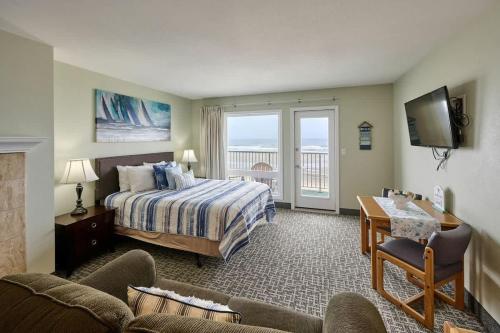 a hotel room with a bed and a desk and a couch at Fireplace Studio - Ground Level - Beach Access - Pool & Hot Tub in Lincoln City