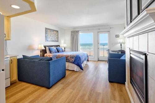 a bedroom with a bed and a couch and a television at Ground Floor Condo - Ocean View - Pool & Hot Tub in Lincoln City