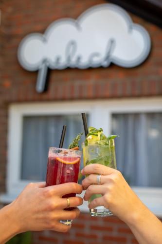 two people holding drinks in their hands at Apartmány Pelech in Trenčianske Teplice
