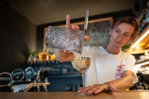a man is pouring a glass in a bar at Apartmány Pelech in Trenčianske Teplice