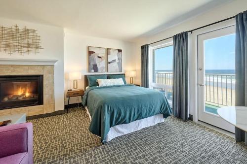 a bedroom with a bed and a fireplace with a view at Ground Floor Studio - Easy Beach Access - Pool and Hot Tub in Lincoln City