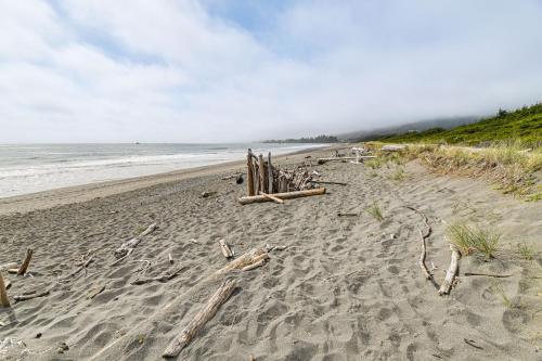 a sandy beach with a fence and the ocean at 3-Acre Property Beachfront Home in Smith River! in Smith River
