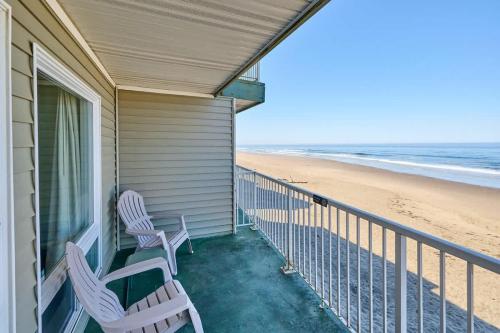 a porch with two chairs and the beach at Fireplace Queen Studio - Ocean View - Pool & Hot Tub in Lincoln City