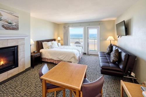 a hotel room with a bed and a fireplace at Oceanfront Studio With Full Kitchen - Beach Access - Pool & Hot Tub in Lincoln City