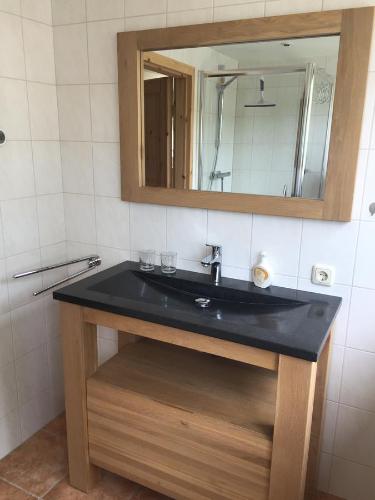 a bathroom with a black sink and a mirror at Bed en Breakfast De Kees in Eersel