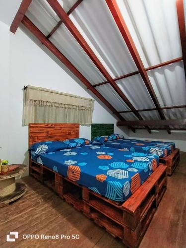 a bedroom with two beds with blue comforter at Habitación Natural Casalegre in Cali