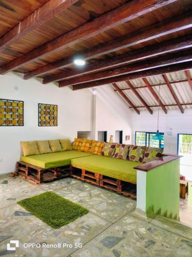a living room with a green couch in a room at Habitación Natural Casalegre in Cali