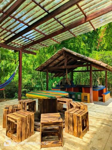 a pavilion with wooden tables and chairs under a roof at Habitación Natural Casalegre in Cali