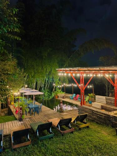 a wooden deck with chairs and a table and lights at Habitación Natural Casalegre in Cali