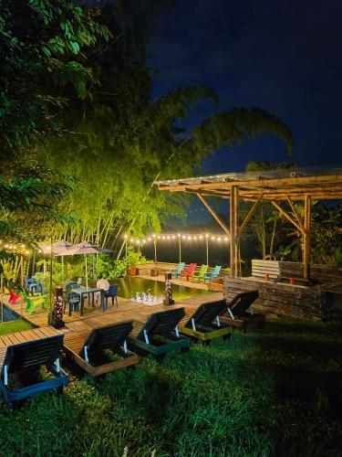 a group of chairs sitting on a deck at night at Habitación Natural Casalegre in Cali