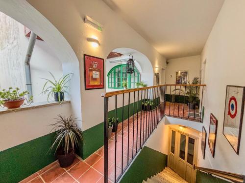 a hallway with a staircase with green and white at Vogel Rooms Tvrđa Osijek in Osijek