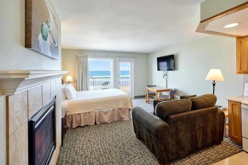 una habitación de hotel con una cama y un televisor en Ground Floor Fireplace Studio - Ocean View & Beach Access - Pool and Hot Tub, en Lincoln City