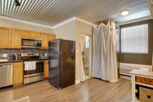 a kitchen with a stainless steel refrigerator and wooden cabinets at Close to Uptown and Hospital Greenwood Studio in Greenwood